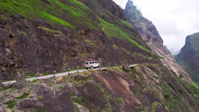 空中越野车沿着山沟在狭窄的道路上行驶。卡利甘达基峡谷