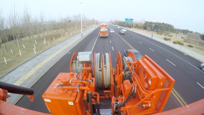 一辆橙色卡车正在进入隧道 公路上有很多车在行使 靠近湖边的意图公路上有很多车在行使