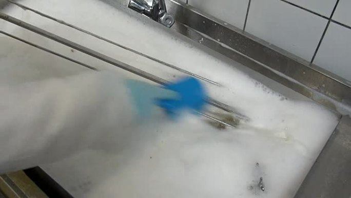 工人手中的蓝色刷子清洁工业烤肉。