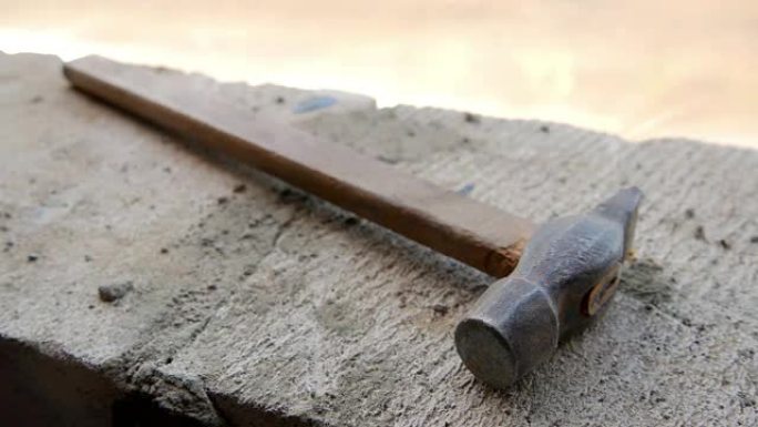 生锈的旧锤子躺在建筑工地上。