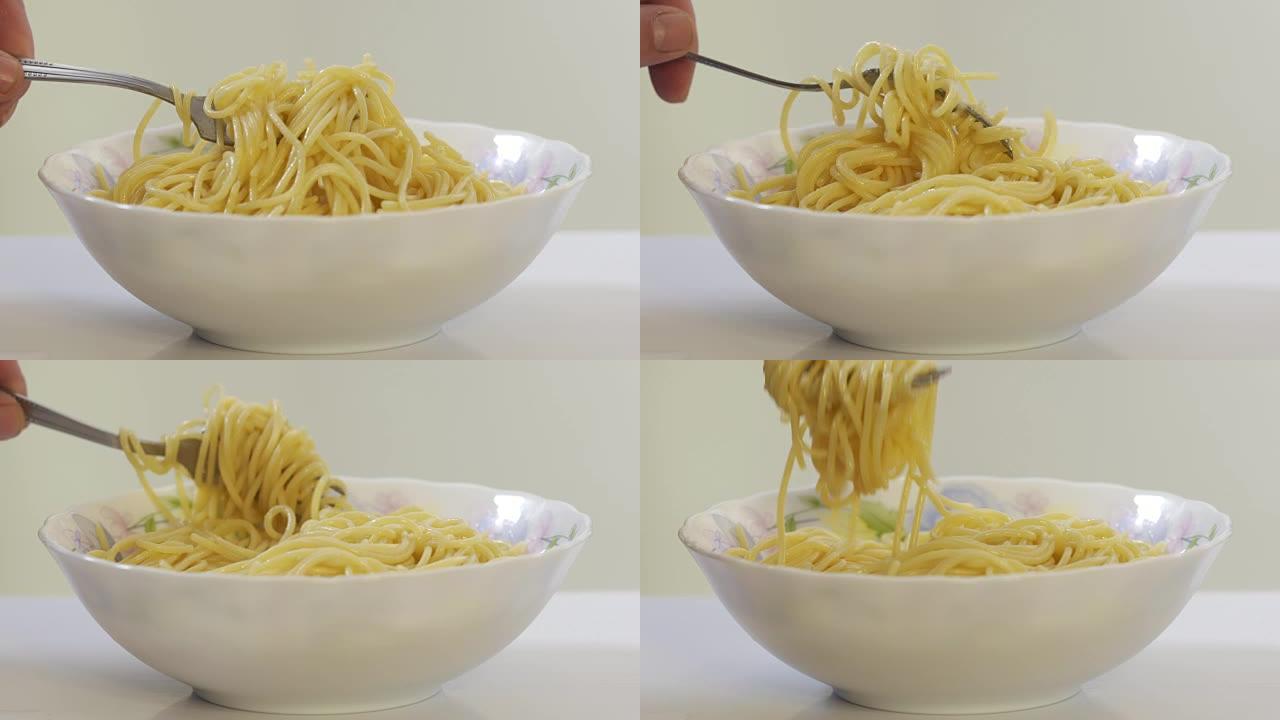 吃意大利面。在叉子的齿周围旋转意大利面条