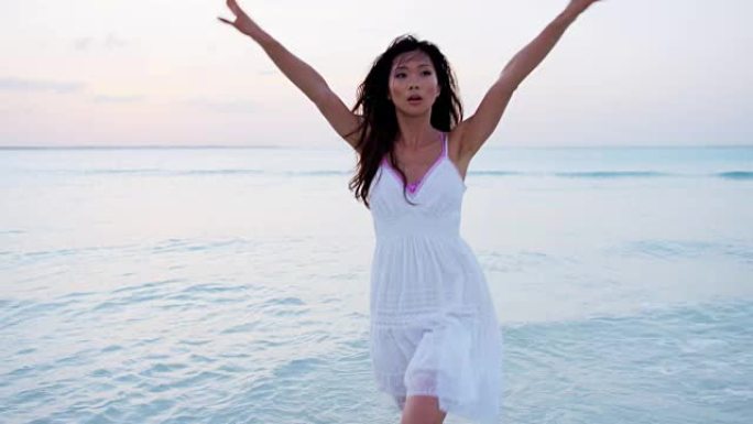 美丽的亚洲华裔女性在热带海滩上跳舞