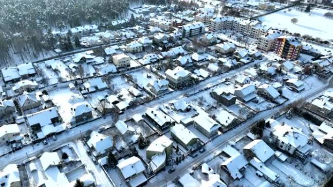 冬天的联排别墅。屋顶房子在雪，顶视图。雪景中的住宅社区。