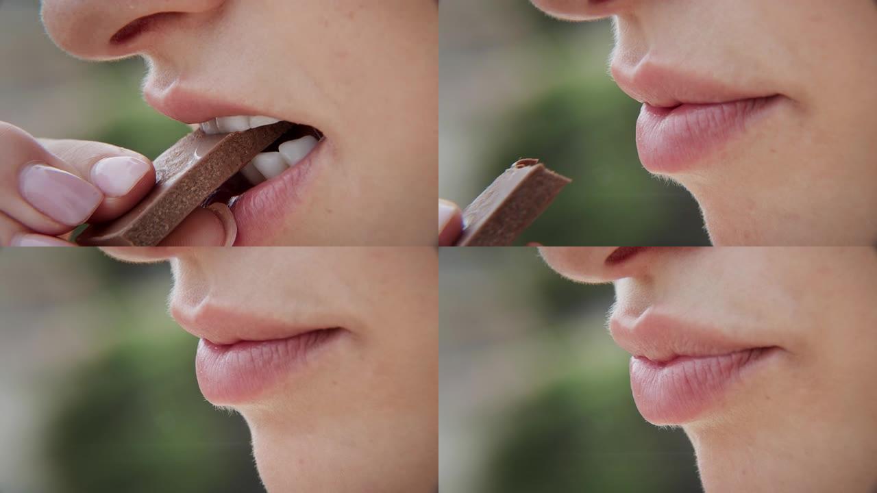 特写性感粉色女性嘴唇满意地咬着甜巧克力棒