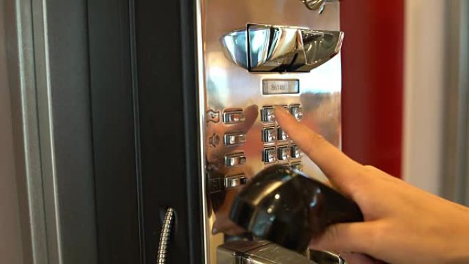 按钮电话机。女人的手抬起电话并拨打电话号码