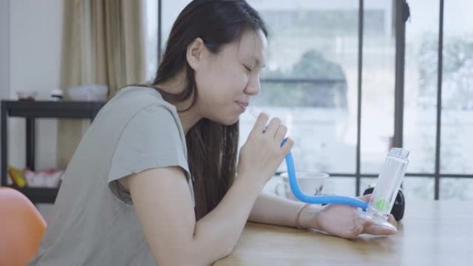 东南亚妇女在家中进行肺功能检查和肺活量测定