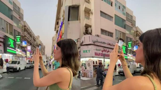 中年妇女在手机上拍摄迪拜街头市场