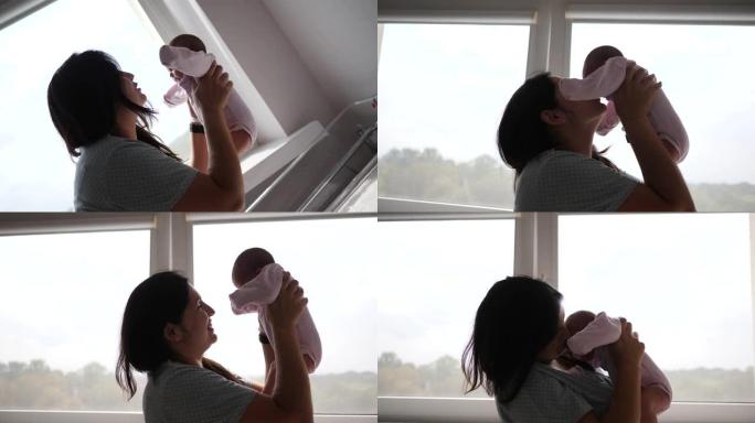 快乐的母亲将她的新生婴儿从妇产医院的病床上抱在窗户旁