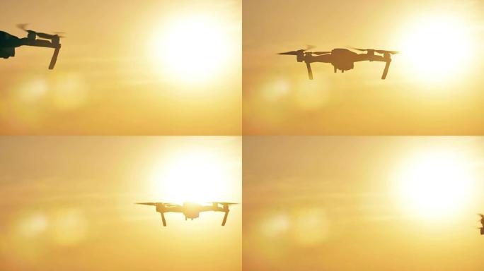 四轴飞行器。无线电控制的无人机在日落时飞走，无人机