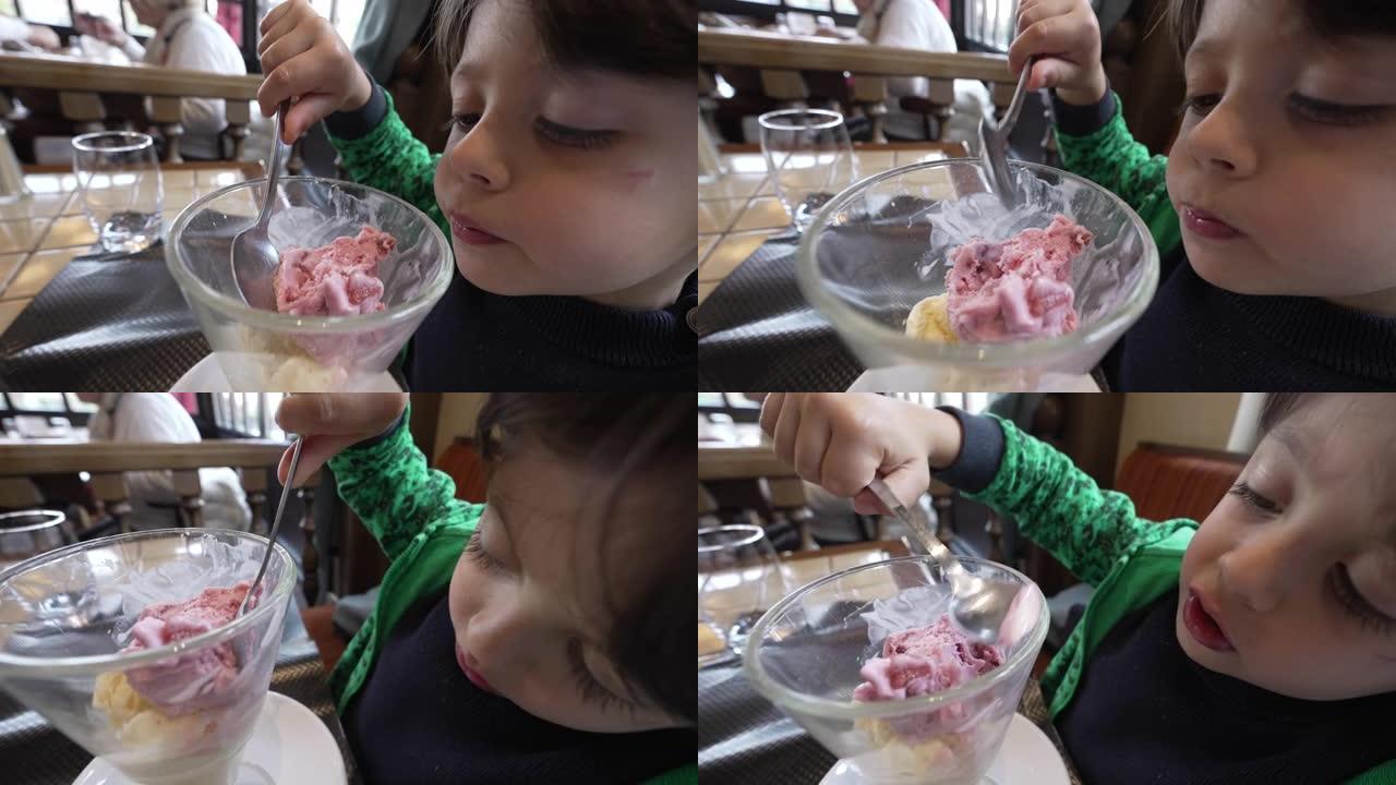 浓缩的孩子用勺子在碗里吃冰淇淋。午餐后坐在餐厅吃甜点的孩子