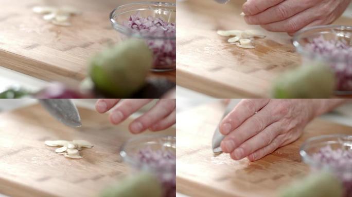 厨师用大菜刀捡起切成薄片的大蒜