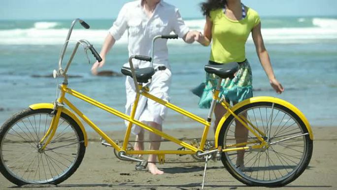 海滩上的情侣，前景是双人自行车