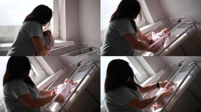 母亲将刚出生的婴儿放在窗户旁边的产科医院病床上