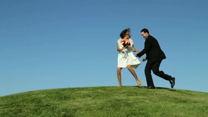 新娘和新郎在草山上奔跑