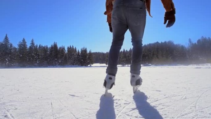 SLO MO TS Man在阳光明媚的冰冻湖上滑冰