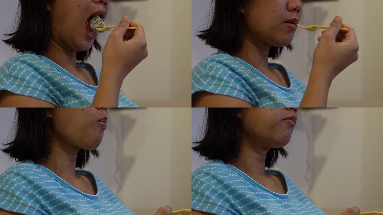 女人正在吃和嚼火龙果。