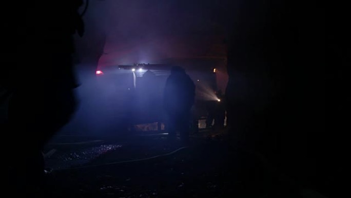 消防员在充满烟雾的黑暗隧道中进行救援行动