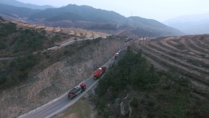 一辆橙色卡车正在进入隧道 公路上有很多车在行使 靠近湖边的意图公路上有很多车在行使