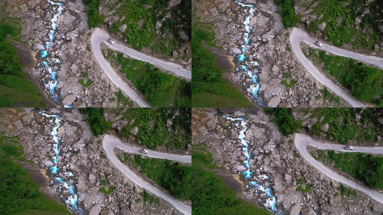 空中SUV沿着河的峡谷在狭窄的道路上行驶