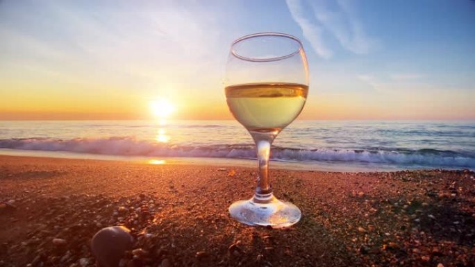 日落时，在美丽的海滩和波浪海上喝杯白葡萄酒。暑假背景