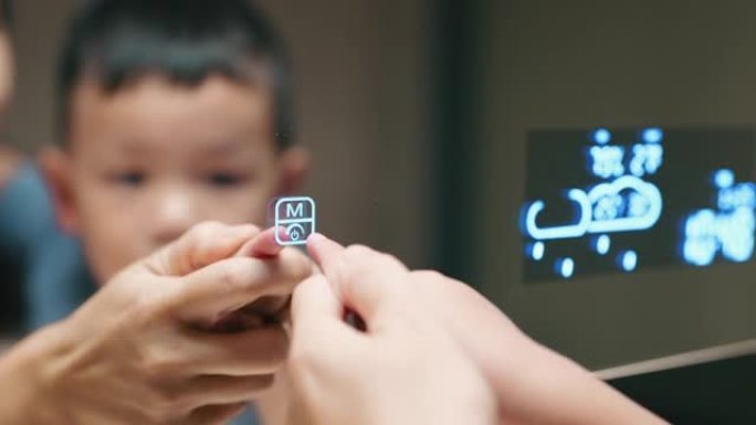 开朗的亚洲妇女抱着儿子在房子里调节和控制灯光。家庭自动化和智能家居技术。
