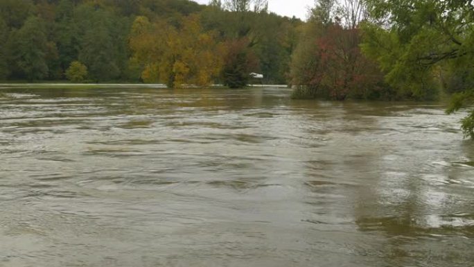 大量降雨后，用秋天的彩色树木淹没了草木河岸