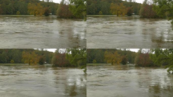 大量降雨后，用秋天的彩色树木淹没了草木河岸