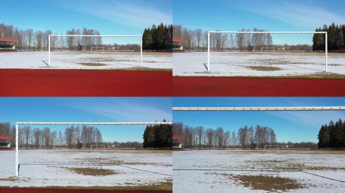 无人机飞过冬季体育场的足球球门，空中