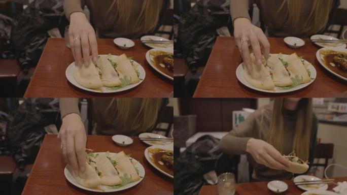 女人在餐厅抢五花肉包三明治