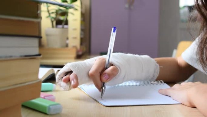 一名手部受伤 (手指骨折) 的学生试图在笔记本上写字。因病做作业困难。手头有选择性的味道。