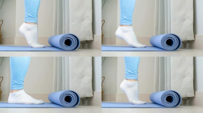 女性腿部做练习提举脚趾特写蓝色背景，侧视图。