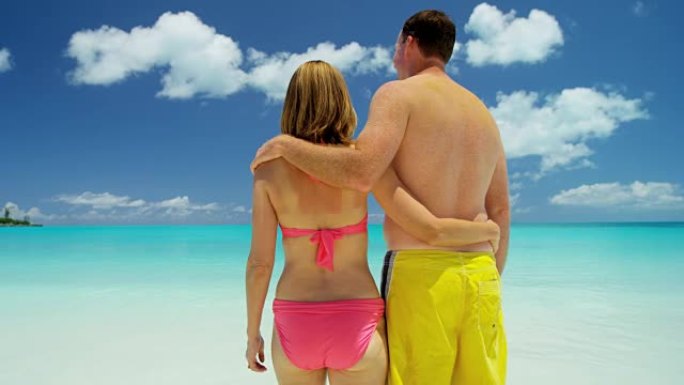 赤脚高加索夫妇在热带海滩上穿着泳装