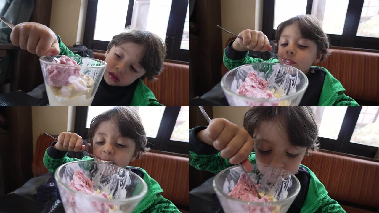 孩子用勺子在碗里吃冰淇淋。午餐后坐在餐厅吃甜点的孩子