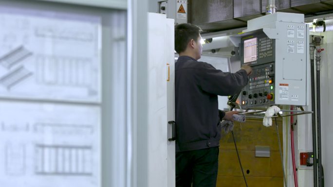 工厂鸟瞰图 一个工人在用钻孔机打孔 一台钻孔机正在打眼