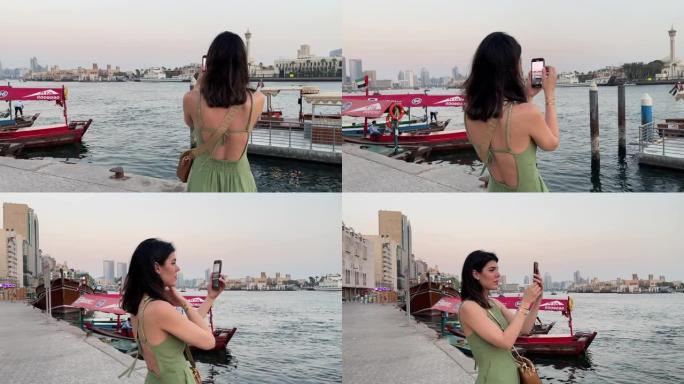 中年妇女在手机上拍摄迪拜溪