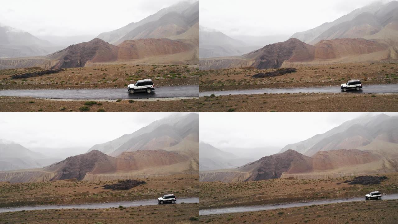 不可阻挡的4x4沿着岩石路径滚动穿过雾气，无人机的视野