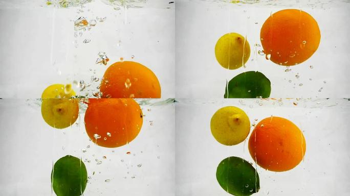 柠檬，石灰和橙子落入水中的慢动作视频带有气泡。
