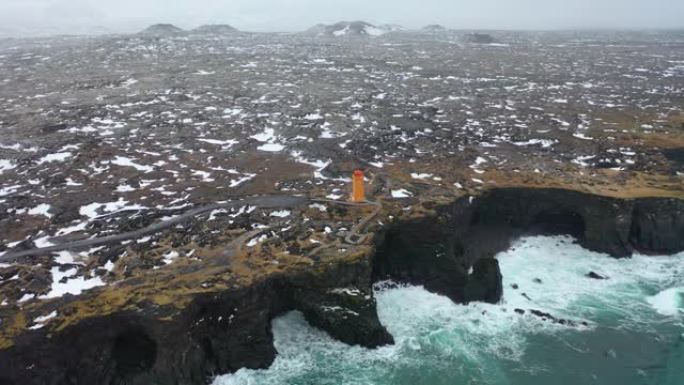 在暴风雨中，海岸线击中大浪的4k航拍画面。碧蓝的水与黑色火山岩相遇。