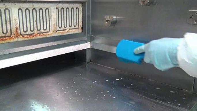 带消毒液的蓝色洗涤刷清洁工业肉烤架。
