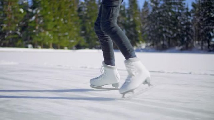 一个女孩的SLO MO TS腿在阳光下的冰冻湖上滑冰