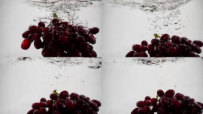 红葡萄的慢动作视频。一束葡萄浸泡在带有气泡的水中。