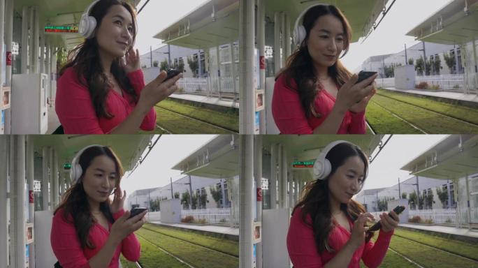 在城市中行走的亚洲女性使用智能手机在耳机中听音乐进行音乐应用，在户外寻找最喜欢的配乐歌手歌曲