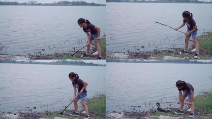 亚洲女孩在大自然中休息和享受，在湖边玩泥