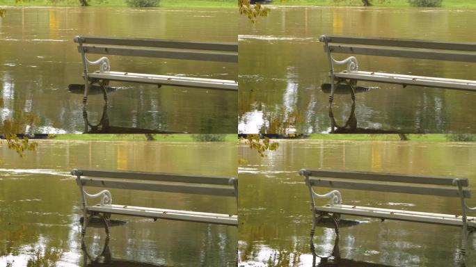 特写: 泥泞的河水被河岸上的白色公园长椅冲刷