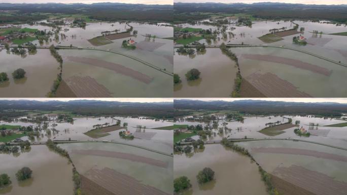 空中大型农业区淹没在村庄附近的泥泞洪水中