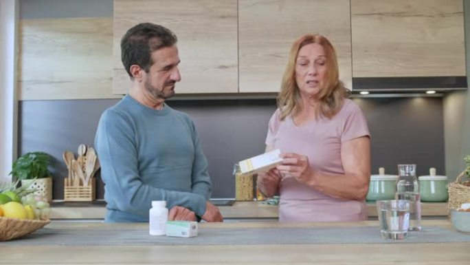 男人和女人谈论厨房柜台上的药