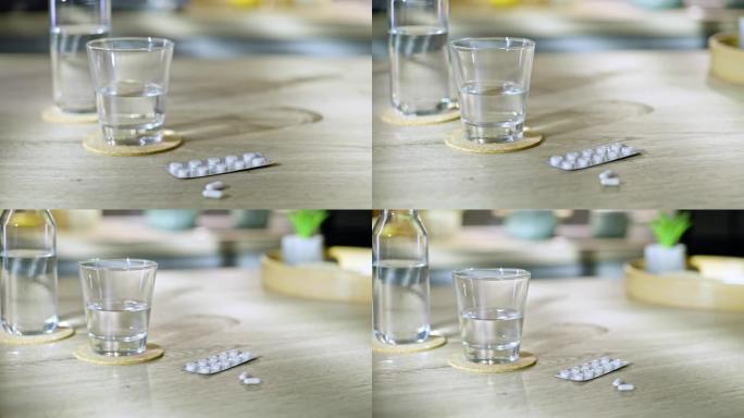 DS泡罩包装的药片放在桌子上，旁边是一杯水