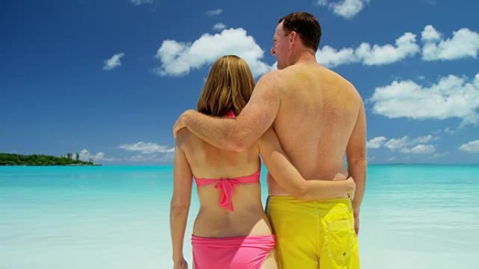 在豪华海滩度假中穿着泳装的高加索夫妇