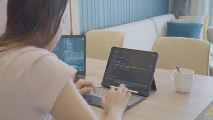 年轻女子在家工作编写打字python程序并学习代码