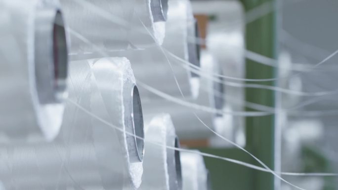 一台纺织机器在工作 一个巨大的白线圈 织布机运转